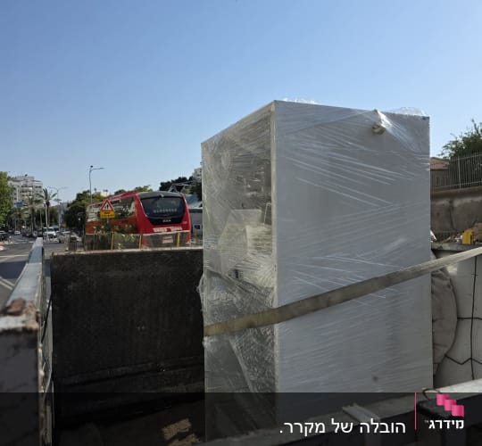 מקרר עטוף בניילון על משאית ברחוב